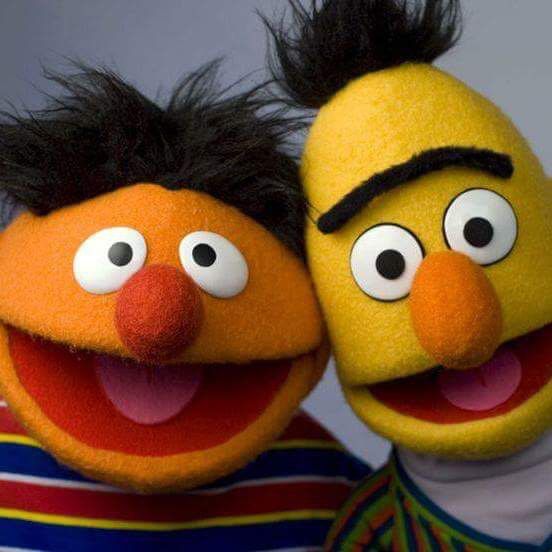 two sesame and bert characters posing for a photo with one holding the other's head