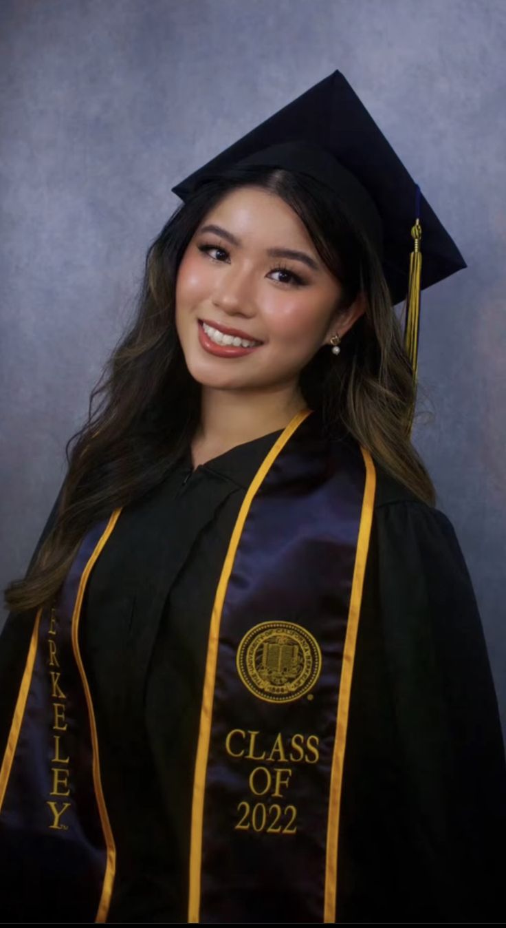 a woman wearing a graduation cap and gown in front of a gray background with the words class of 202 written on it