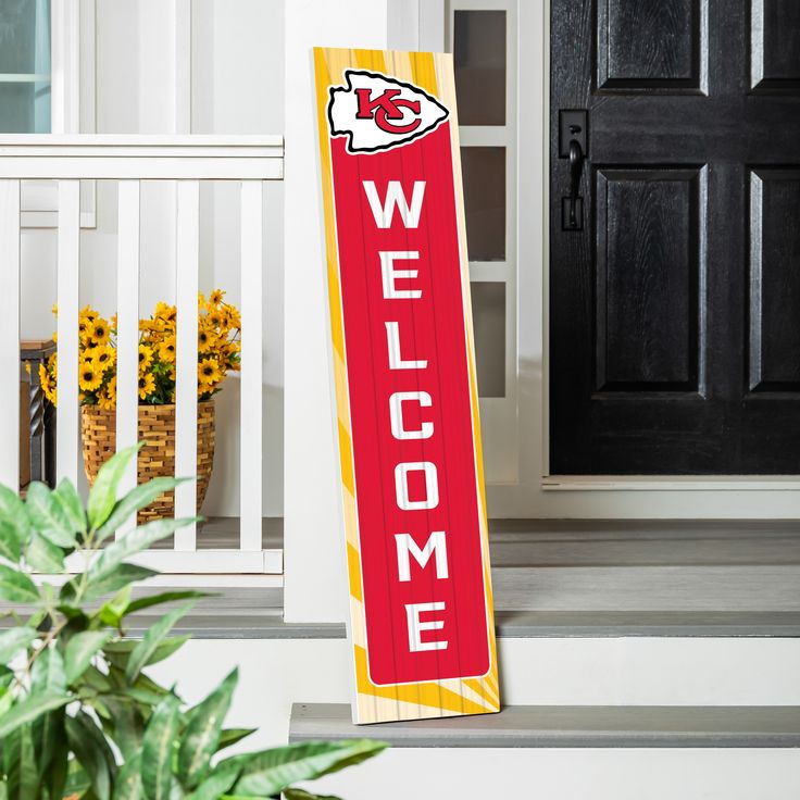 a welcome sign on the front steps of a house with potted plants and sunflowers