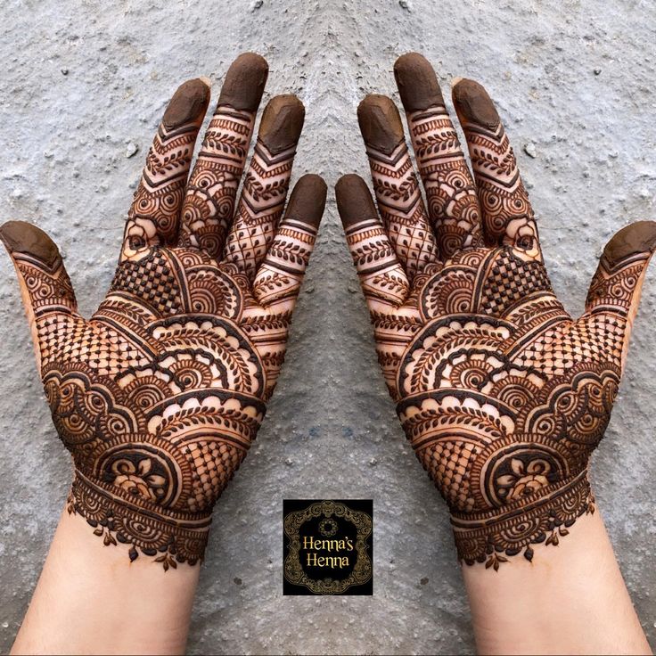 two hands with henna designs on them and the words happy homa written in arabic