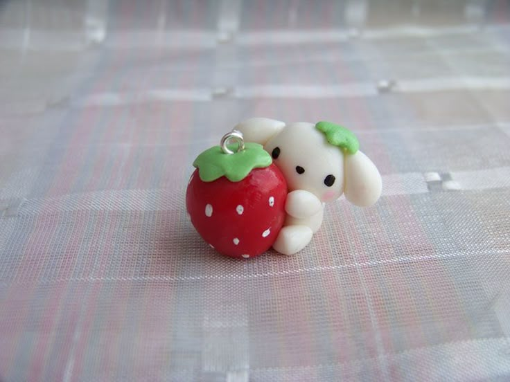 a small figurine is sitting on a plaid tablecloth with an apple in the shape of a dog