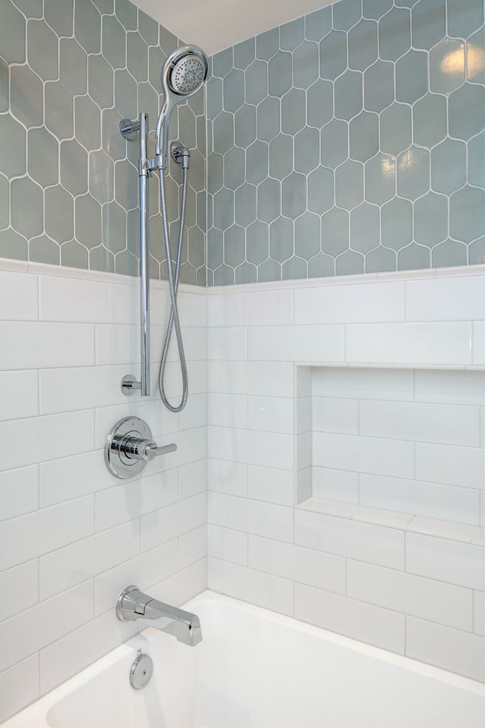 a white bath tub sitting next to a shower head