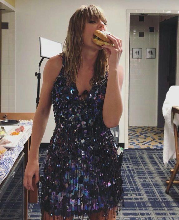 a woman in a sequin dress eating a donut