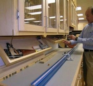 a man standing in front of a counter with some blue tape on it and a pair of scissors