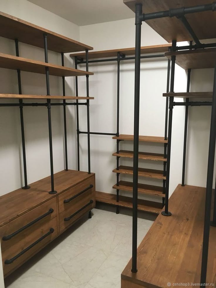 an empty walk in closet with wooden shelves and shelving units on the wall,