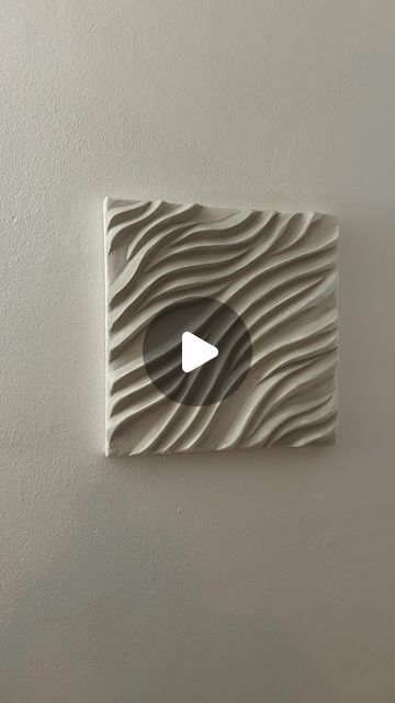 a white wall with a video playing on it's screen and an image of waves in the background