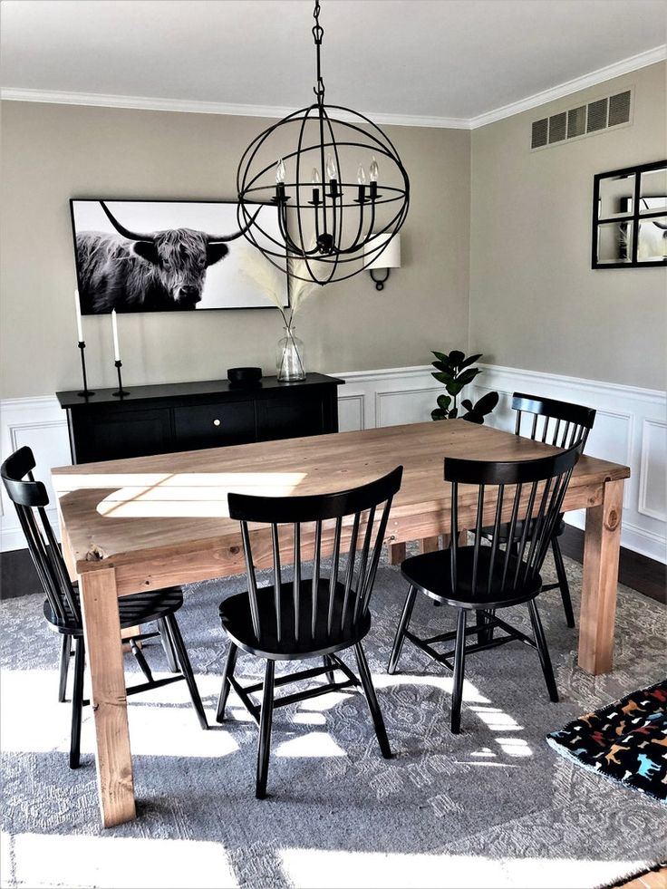 a dining room table with four chairs and a chandelier hanging from the ceiling