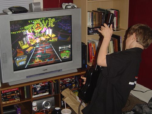 a young boy playing a video game on the nintendo wii in front of a tv