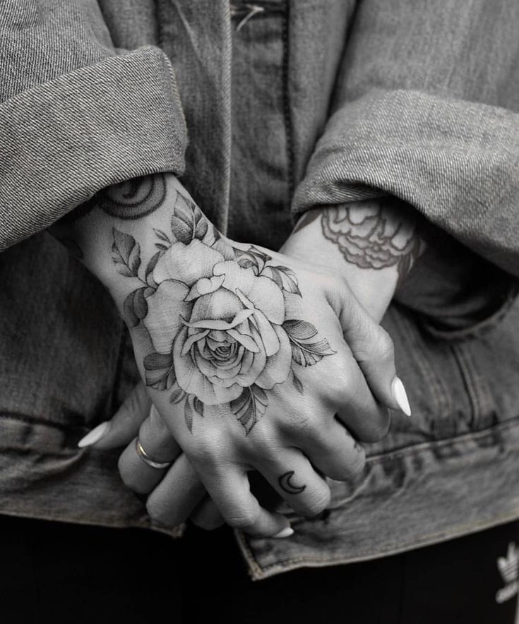 a person holding their hands with tattoos on them