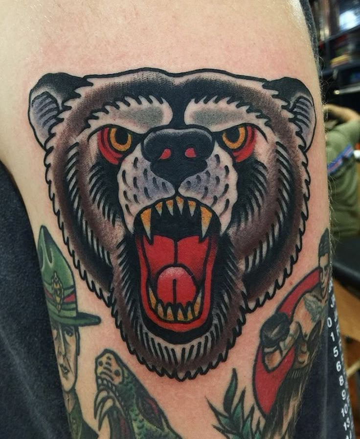 a man with a tattoo on his arm has a bear's head and teeth