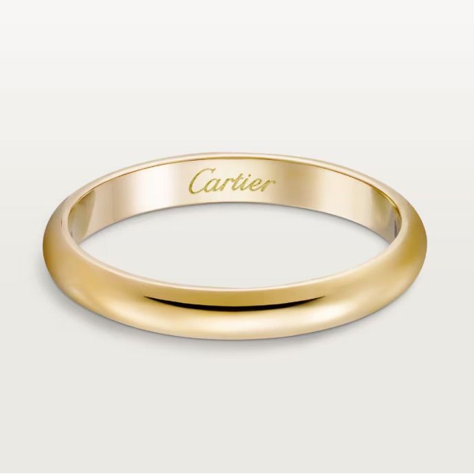 a yellow gold wedding band with the word carrier engraved on it's side, in front of a white background