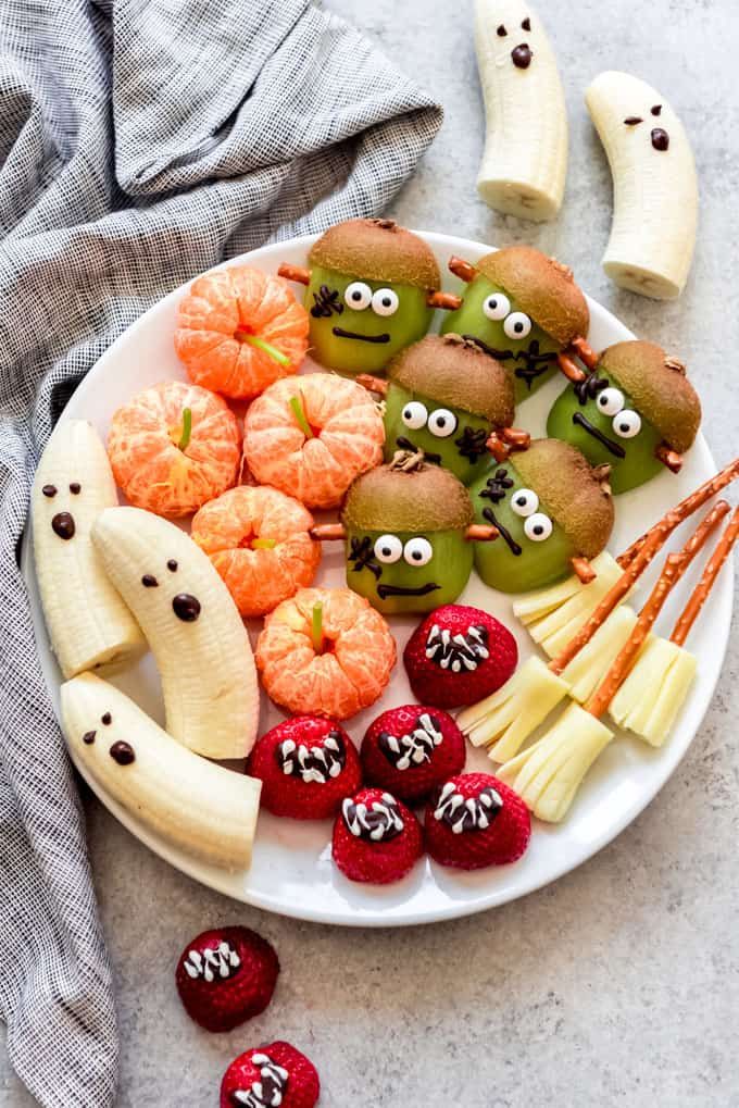 a white plate topped with fruits and veggies covered in googly eye eyes