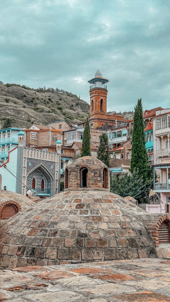 an old stone building with a clock tower in the middle of it's roof