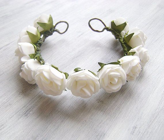 a white flower headband with green leaves