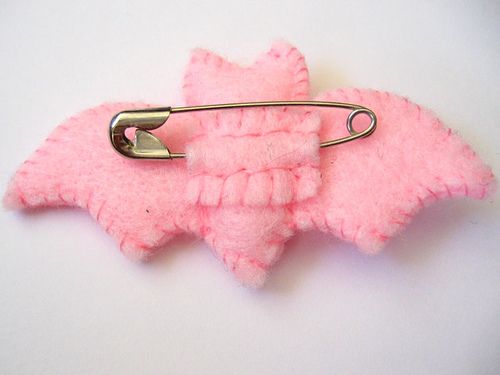 a pink brooch with a metal hook attached to it