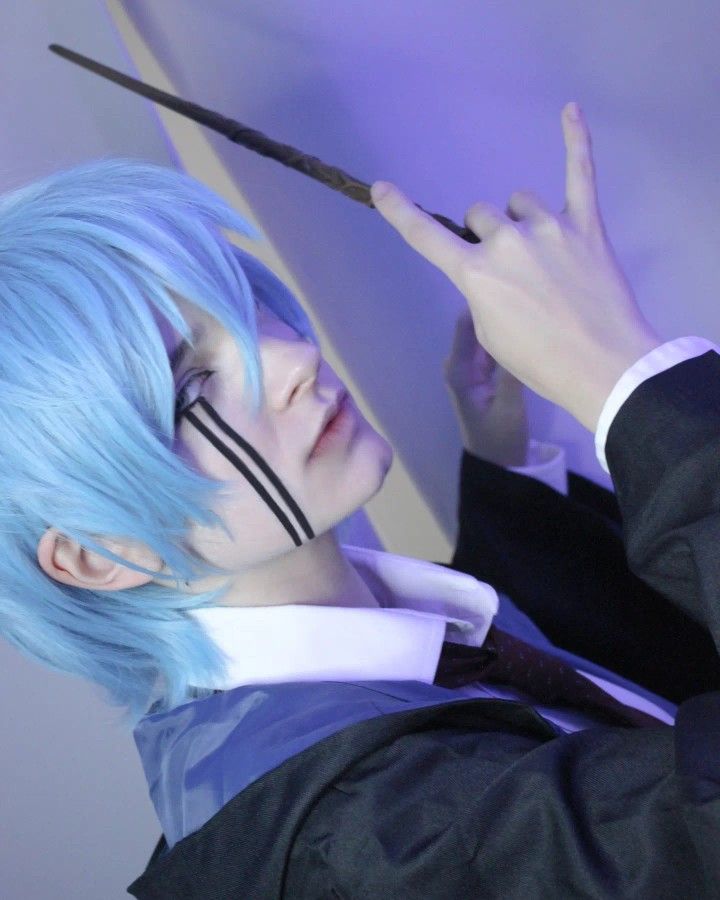 a man with blue hair holding a pair of scissors