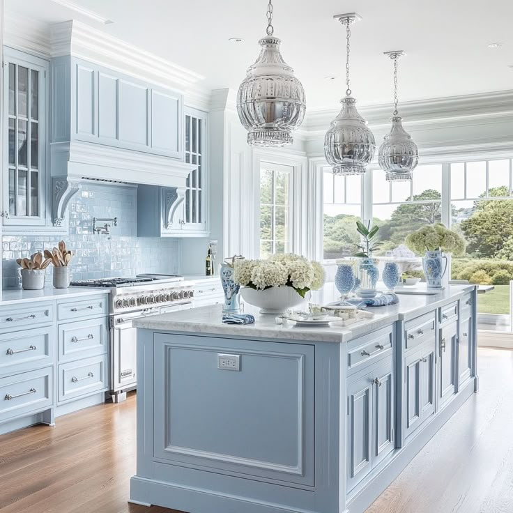 a large kitchen with blue cabinets and marble counter tops, an island in the middle