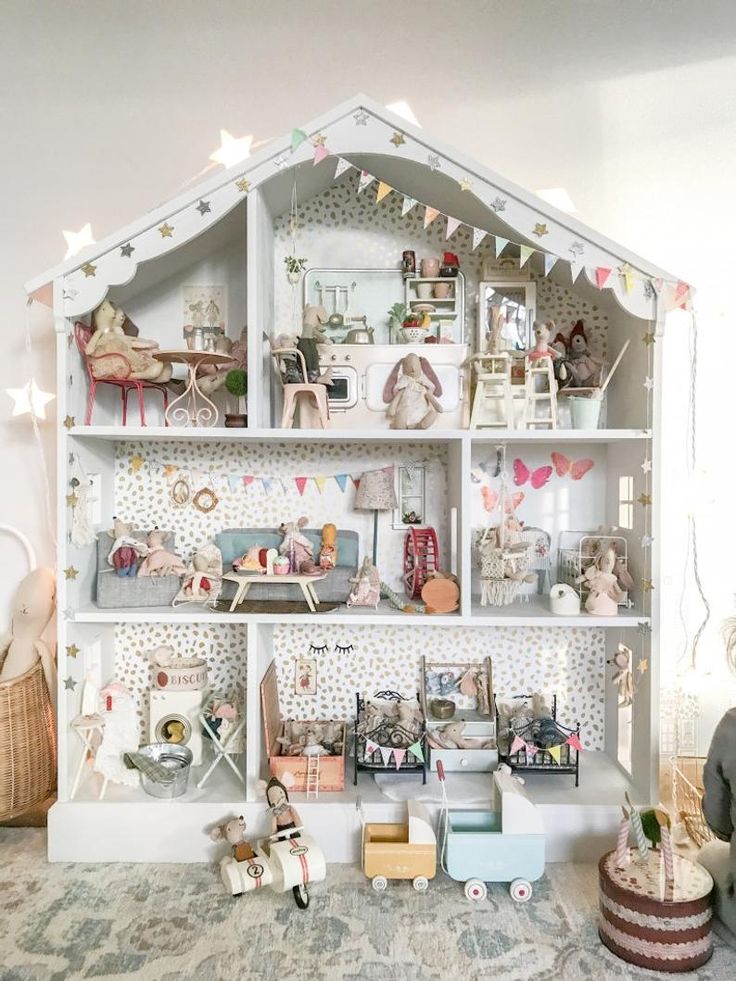 a doll house with lots of furniture and decorations on it's shelves in a living room