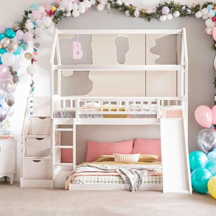 a room decorated with balloons, garlands and a bunk bed in the middle of it