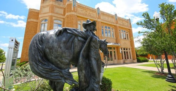 a statue of a man riding a horse in front of a building