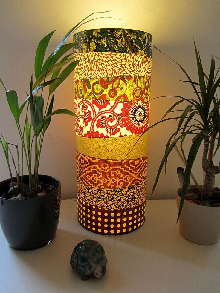 a lamp that is sitting on top of a table next to some potted plants