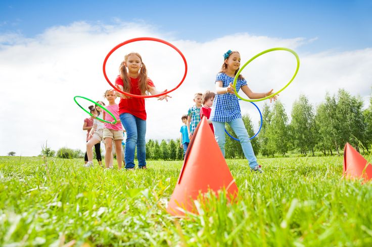 two girls are playing with hula hoops in the grass