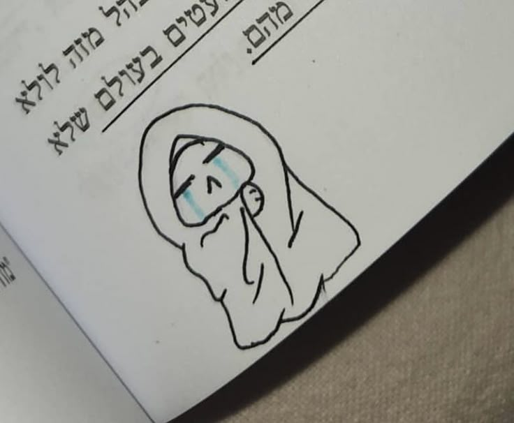 an open book with a drawing of a woman's face and words in hebrew