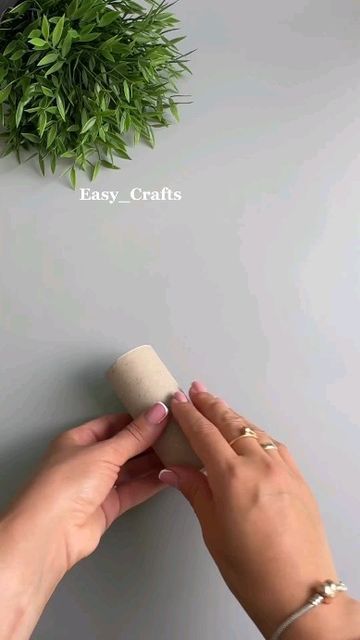 two hands are holding a cork with the word easy crafts on it and a plant above