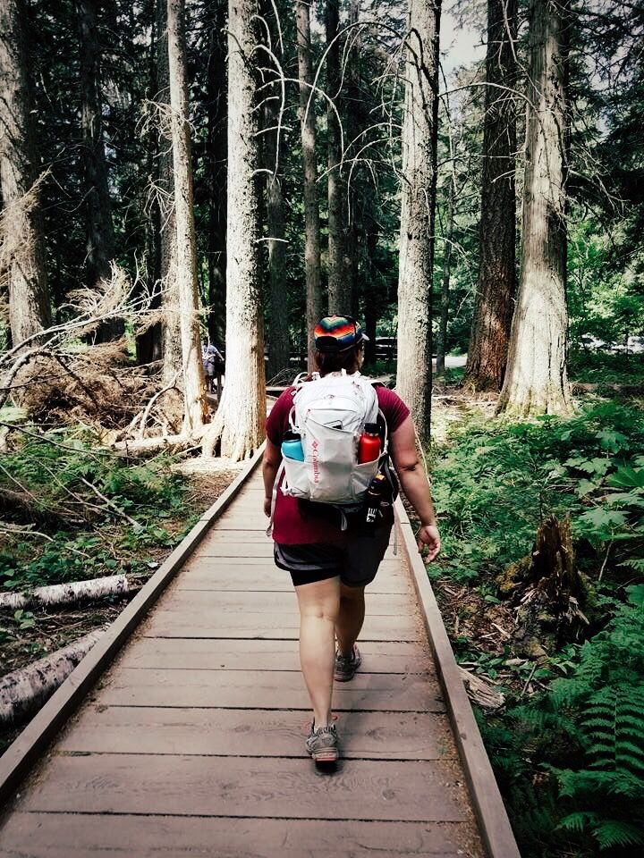 a person with a backpack walking on a wooden path