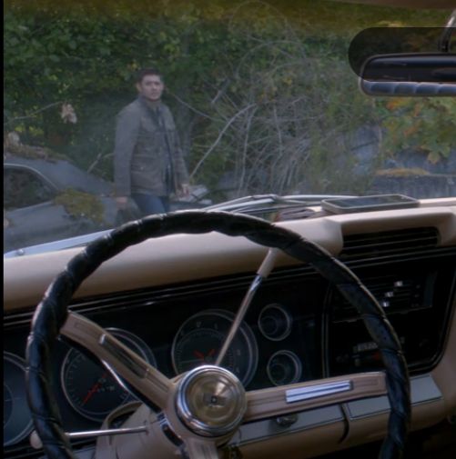 a man standing behind the steering wheel of a car