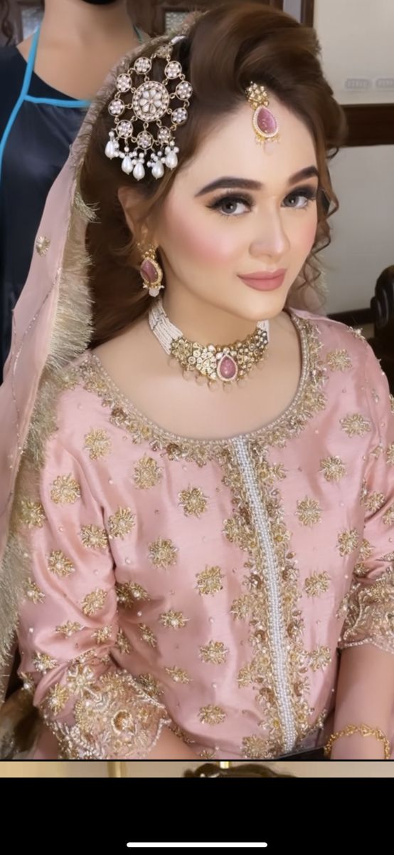 a woman wearing a pink bridal outfit