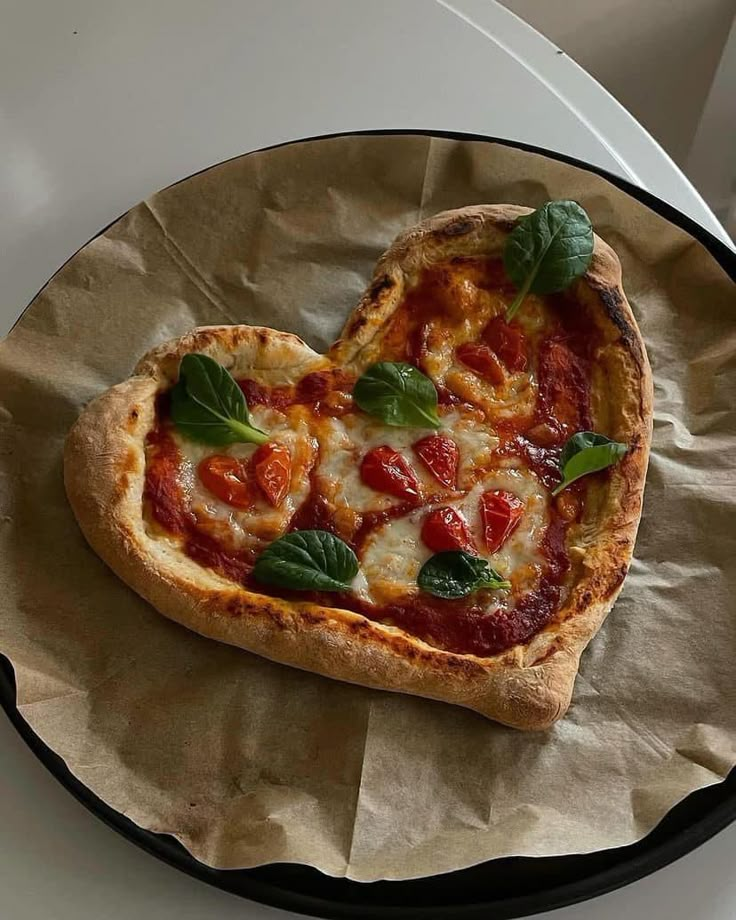 a heart shaped pizza sitting on top of a plate