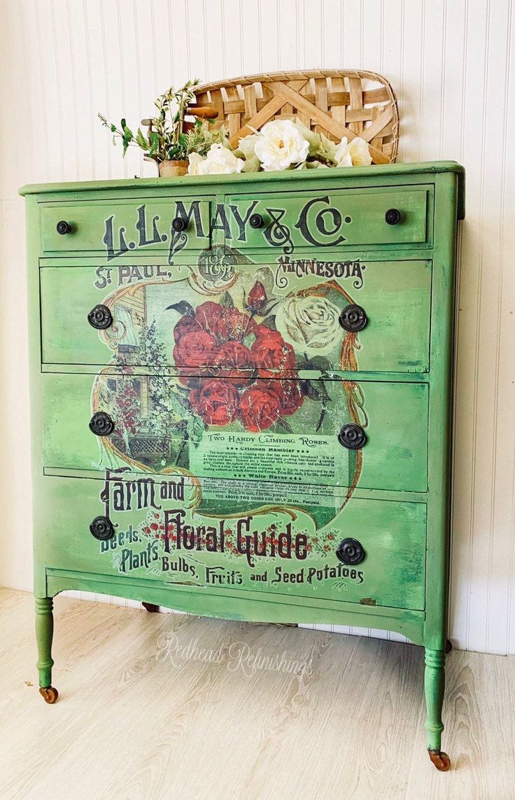 a green painted dresser with flowers on top