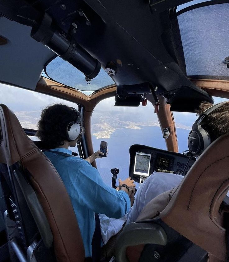 two pilots in the cockpit of an airplane looking at something on their tablet computer screen