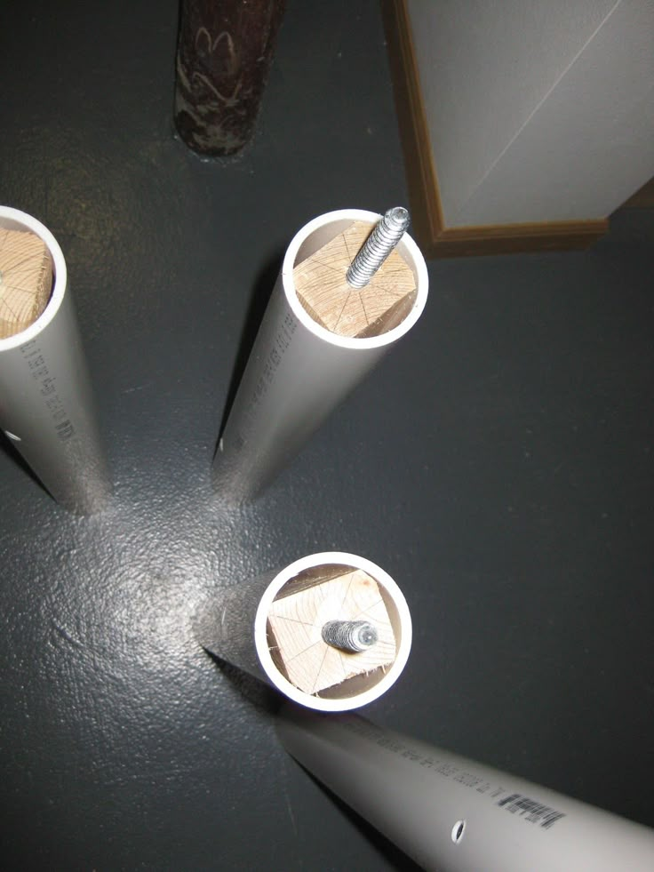 three white cups with toothbrushes in them on a table