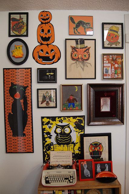 the wall is covered with many halloween pictures and pumpkins, including an old typewriter