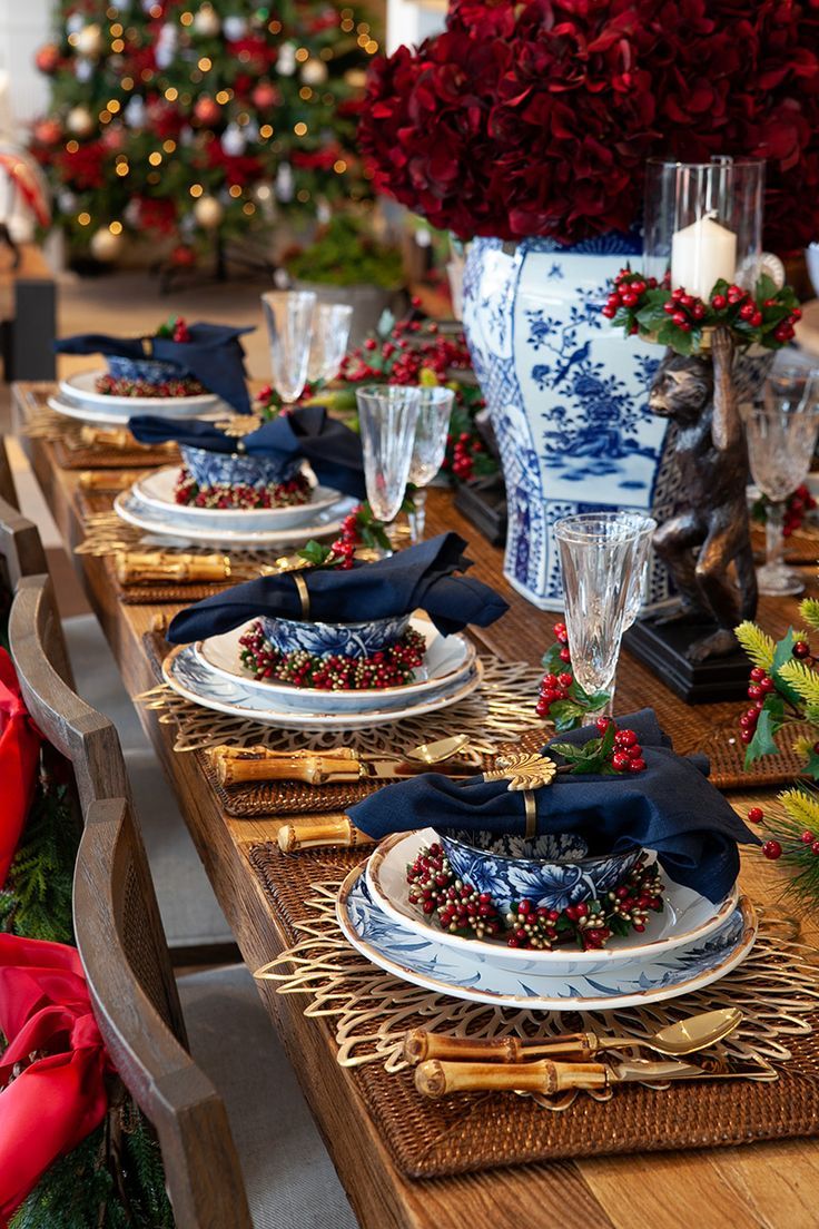 the table is set with blue and white plates, silverware, and red napkins