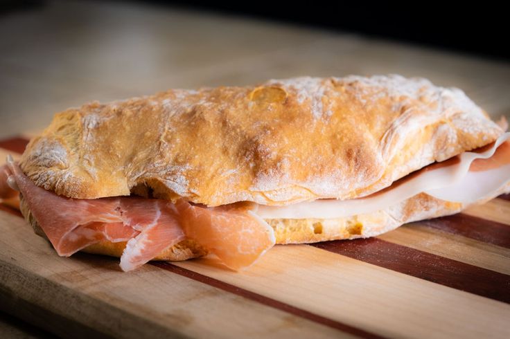 ham and cheese sandwich sitting on top of a cutting board