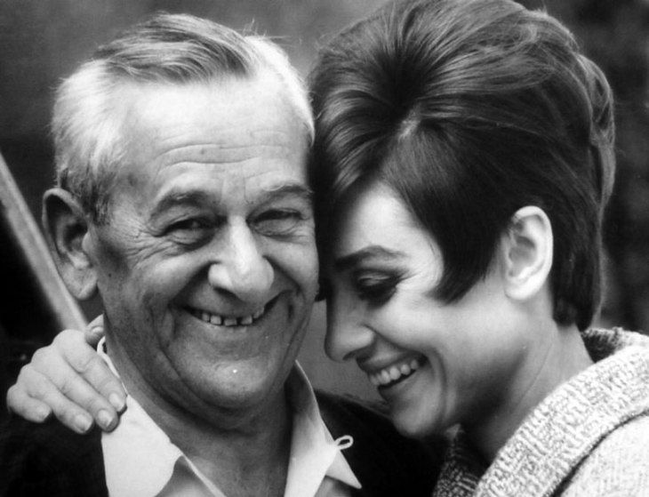 an older man and woman smile as they pose for a black - and - white photo