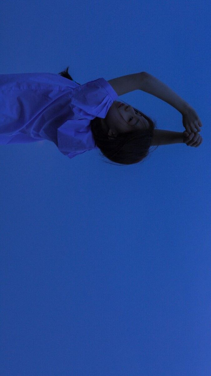 a woman flying through the air while wearing a blue shirt