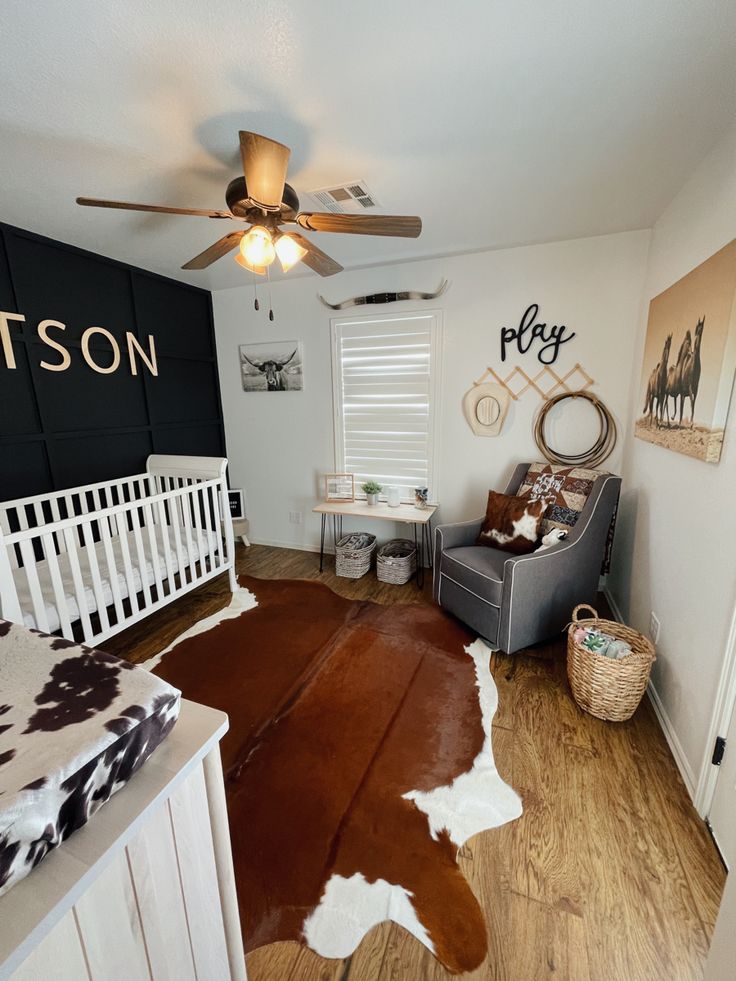 a baby's room with a cow skin rug on the floor