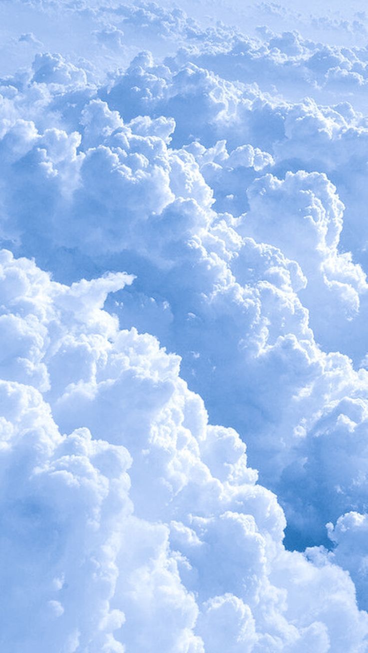 the view from an airplane looking down on some fluffy white clouds and blue sky above