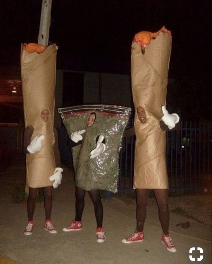 three people dressed in costumes holding up bags