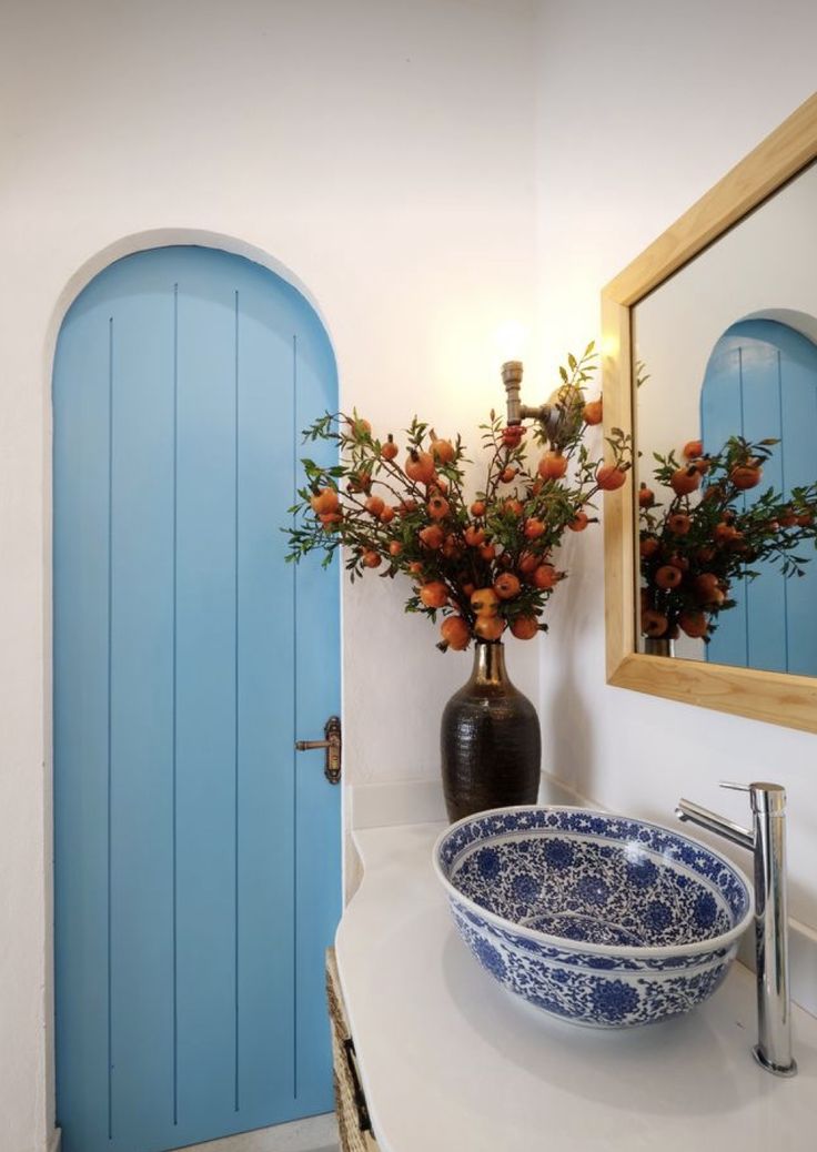 a blue and white bowl sitting on top of a bathroom counter next to a mirror