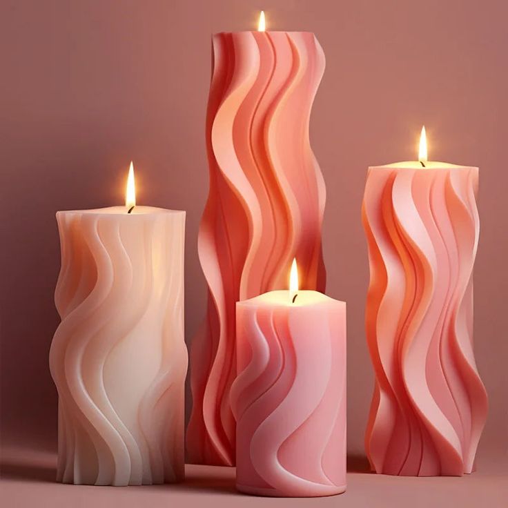 three candles that are sitting next to each other on a table and one is pink with white swirls