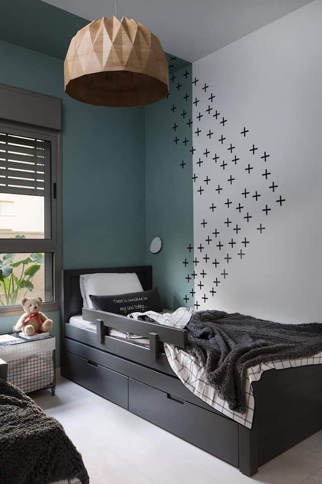 a bed room with a neatly made bed next to a window and a teddy bear