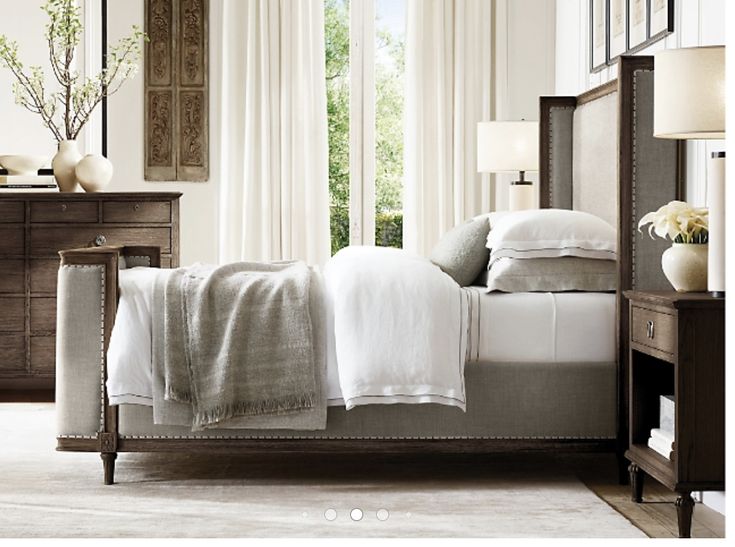 a bed sitting in a bedroom next to a dresser and chair on top of a hard wood floor