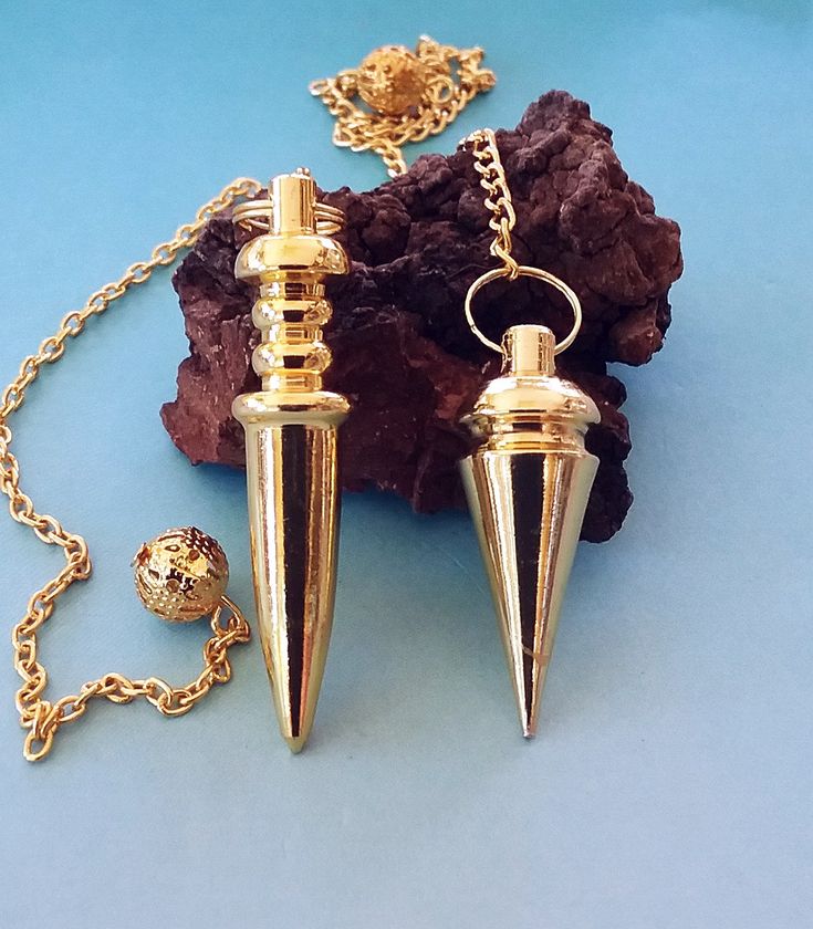 "Solid Brass lathed dowsing pendulums with gold plating. One long sword design and one teardrop point. A very powerful professional healing pendulum tool .Includes attached chains and drawstring storage bags. The teardrop shaped pendulums measure 1.25\" long and the sword design is almost 2\" long. Nicely weighted and indestructible." Pendulum Dowsing, Divination Tools, Storage Bags, Gold Plating, Gold Finish, Solid Brass, Bag Storage, Arrow Necklace, Sell On Etsy