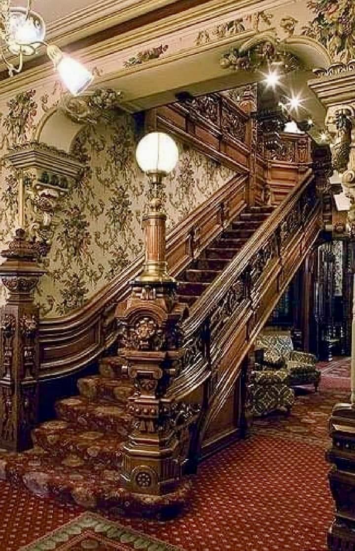 an ornately decorated staircase and chandelier in a building