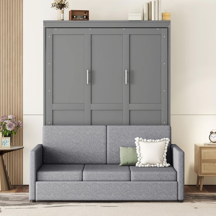 a living room with a gray couch and some cabinets on the wall next to it